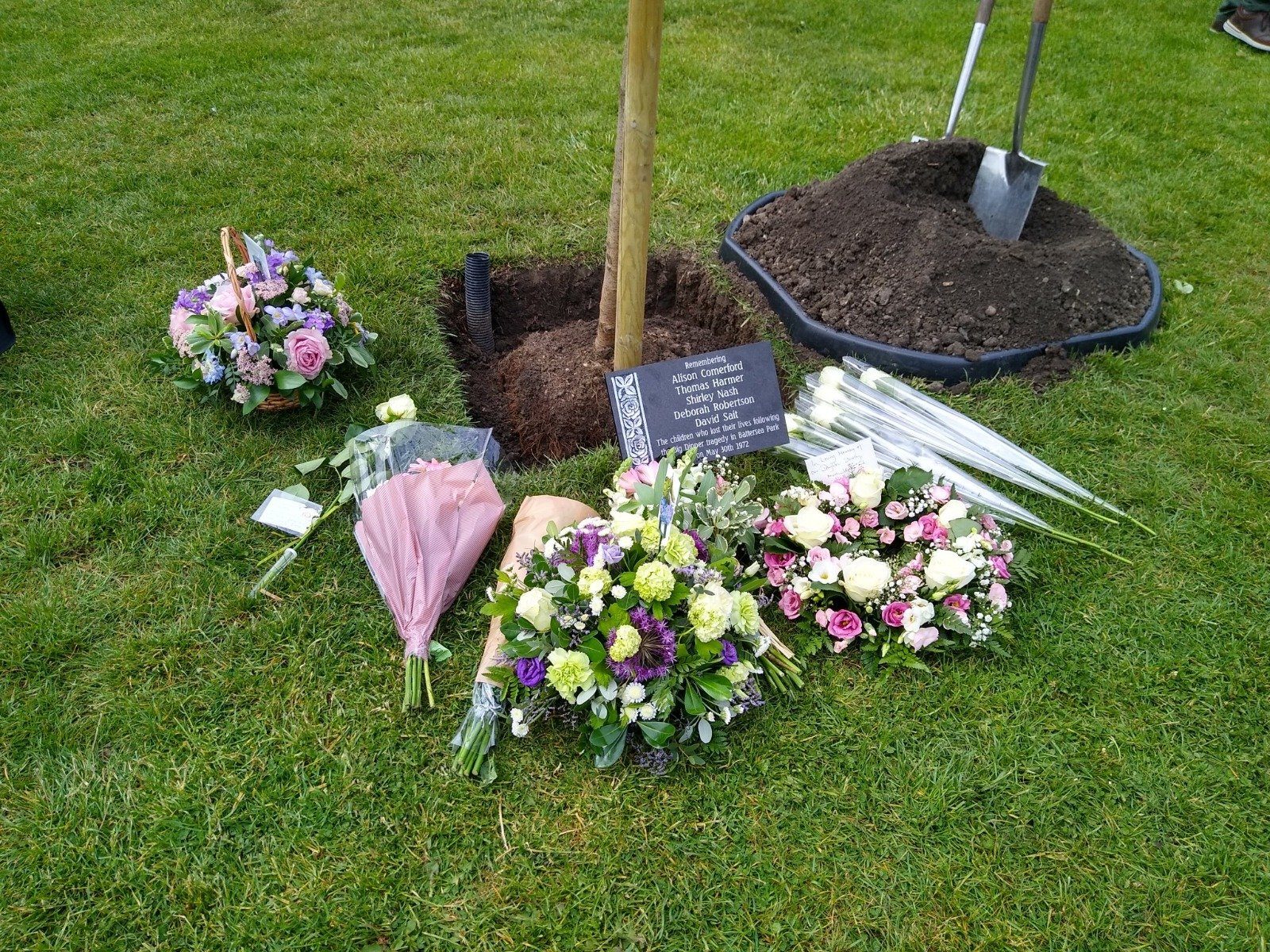 An image of flowers left at the memorial tree for the five young victims of the Battersea funfair disaster.