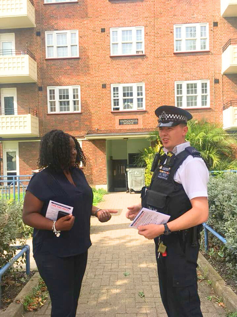Marsha on a housing estate with a Met police officer.